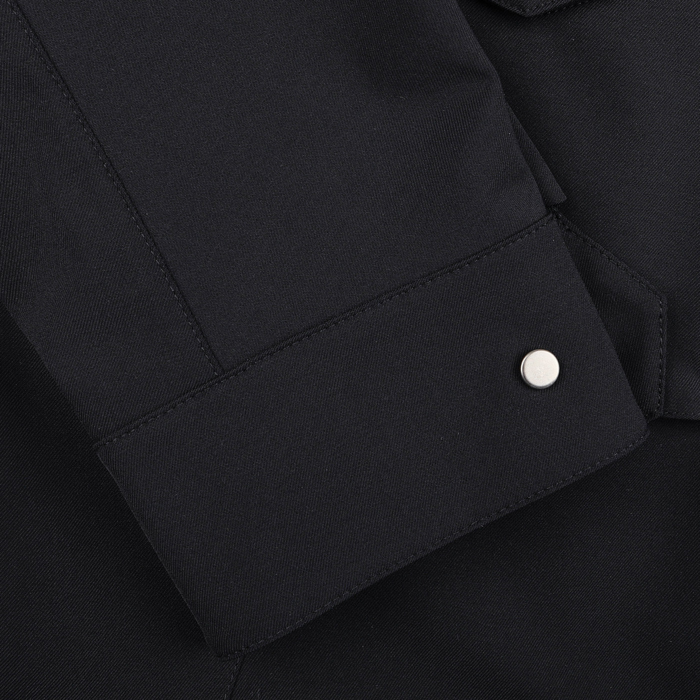 Close-up of a sleeve from the Montecore Midnight Blue Aéro Twill Field Jacket, featuring a metal cuff button that echoes the finesse of Italian outerwear craftsmanship.