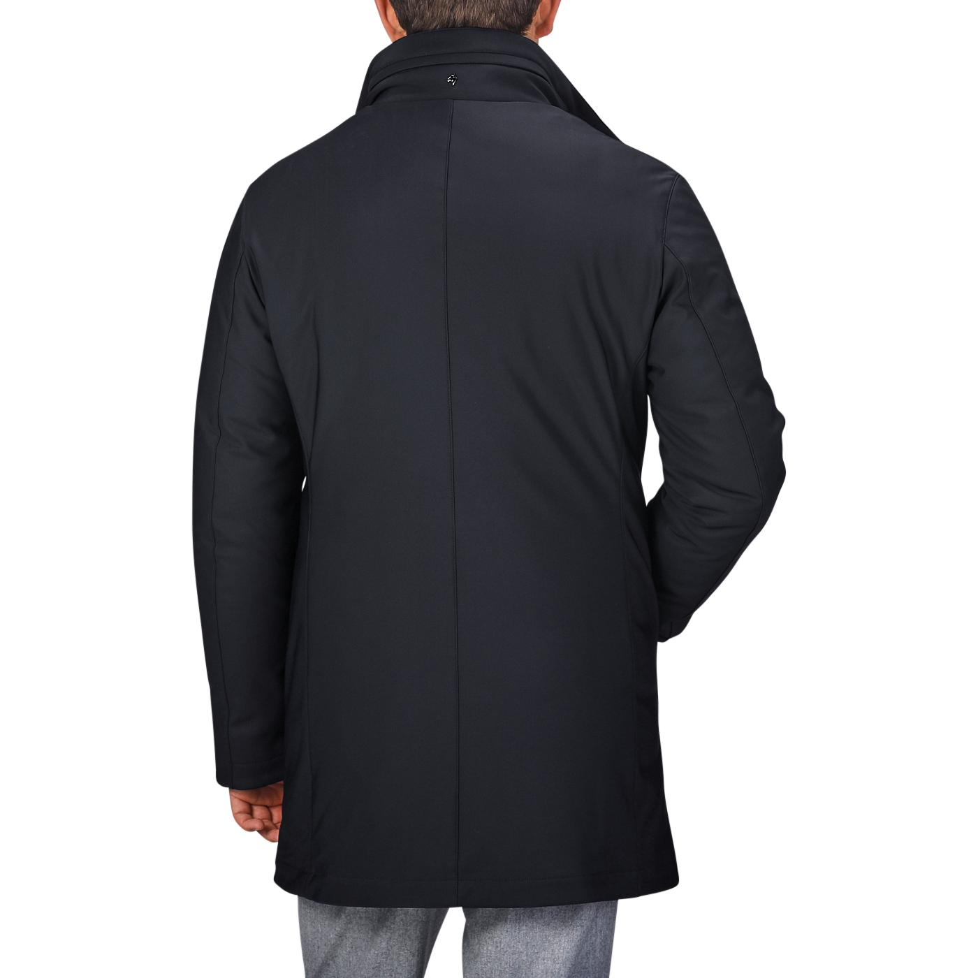 Back view of a person wearing a navy blue Montecore nylon technical padded car coat with a standing collar and grey pants.