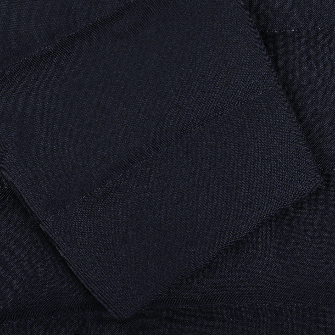 Close-up of a folded Navy Blue Super 120s Wool Batavia Padded Coat with visible stitching, showing the texture and detail of this Montecore material, exemplifying fine Italian outerwear craftsmanship.