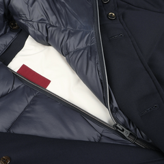 A close-up of a Montecore Navy Blue Super 120s Wool Batavia Padded Coat partially unzipped to reveal its inner lining, which features navy fabric with white underneath and a distinctive red tab.