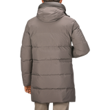 A person wearing a Montecore Taupe Beige Nylon Down Padded Parka with a hood, facing away from the camera.