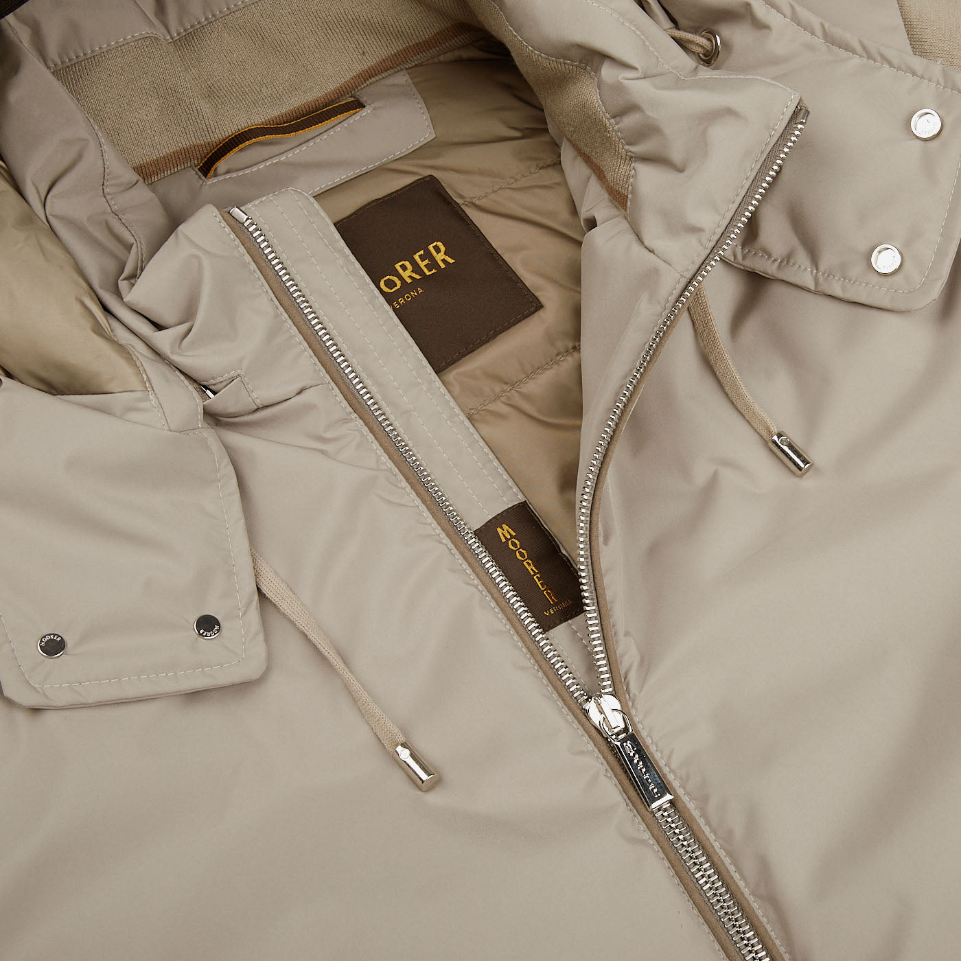 A close up of a Beige Down Padded Knitted Sleeve Bomber jacket with a zipper by Moorer.