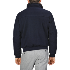 A person is shown from behind, clad in a sleek Navy Blue Cashmere Blend Down Padded Blouson by Moorer and gray pants.