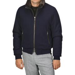 A man wearing a Moorer Navy Blue Cashmere Blend Down Padded Blouson with a brown collar and light gray pants.