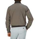 Man wearing a Moorer Olive Green Technical Nylon Blouson and light-colored pants viewed from the back.