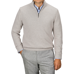 Man wearing a Taupe Beige Wool Cashmere Quarter Zip sweater by Morgano over a blue collared shirt, paired with gray trousers, standing against a neutral background.