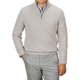 Man wearing a Taupe Beige Wool Cashmere Quarter Zip sweater by Morgano over a blue collared shirt, paired with gray trousers, standing against a neutral background.