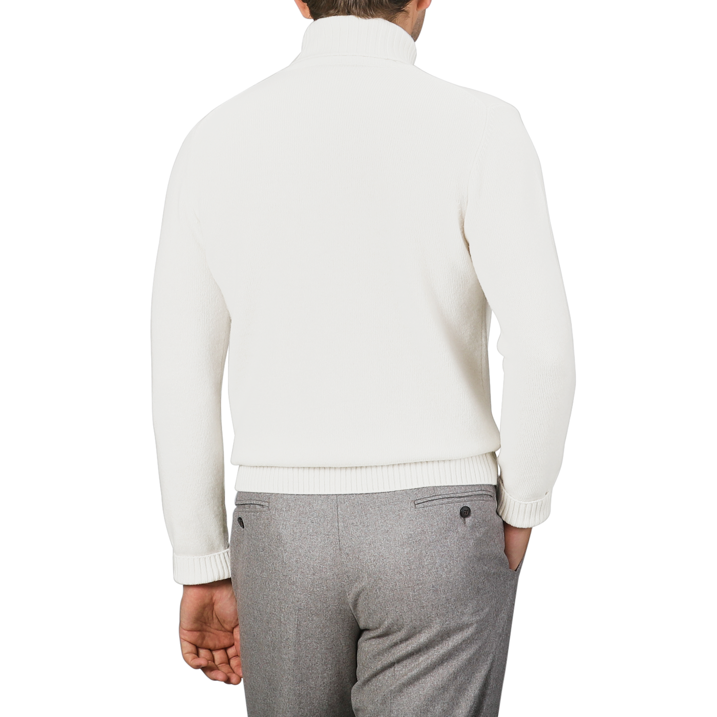 A man in a cream heavy wool cashmere rollneck by Morgano and gray pants is shown from the back against a subtle light gray background.