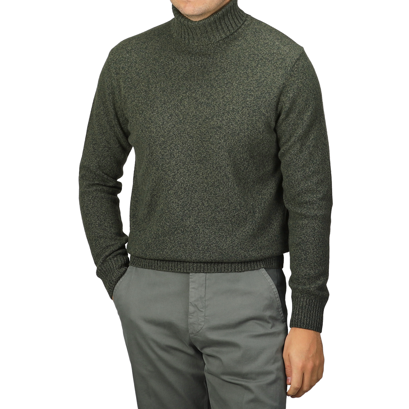 A person wearing a Green Melange Heavy Wool Cashmere Rollneck by Morgano and gray pants, with hands in pockets.