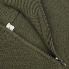 Close-up of the Moss Green Wool Cashmere Quarter Zip by Morgano, showcasing a luxurious blend of merino wool and cashmere, a visible zipper, and a small fabric label partially visible on the inside.