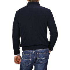 Back view of a person wearing a Morgano Navy Blue Wool Cashmere Quarter Zip and blue jeans, standing against a plain gray background.