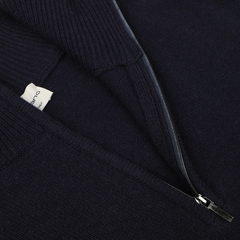 Close-up of the Morgano Navy Blue Wool Cashmere Quarter Zip sweater with a partially unzipped metal zipper, revealing a white clothing label inside. Crafted by an Italian knitwear specialist, this luxurious piece is made from the finest blend of merino wool and cashmere.