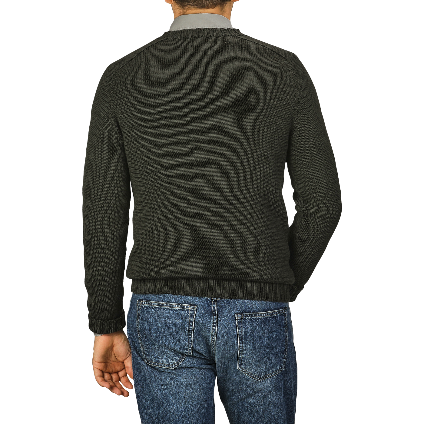 A person is standing with their back to the camera, wearing a Khaki Green Merino Wool Garbis Sweater by Nitto and blue jeans.