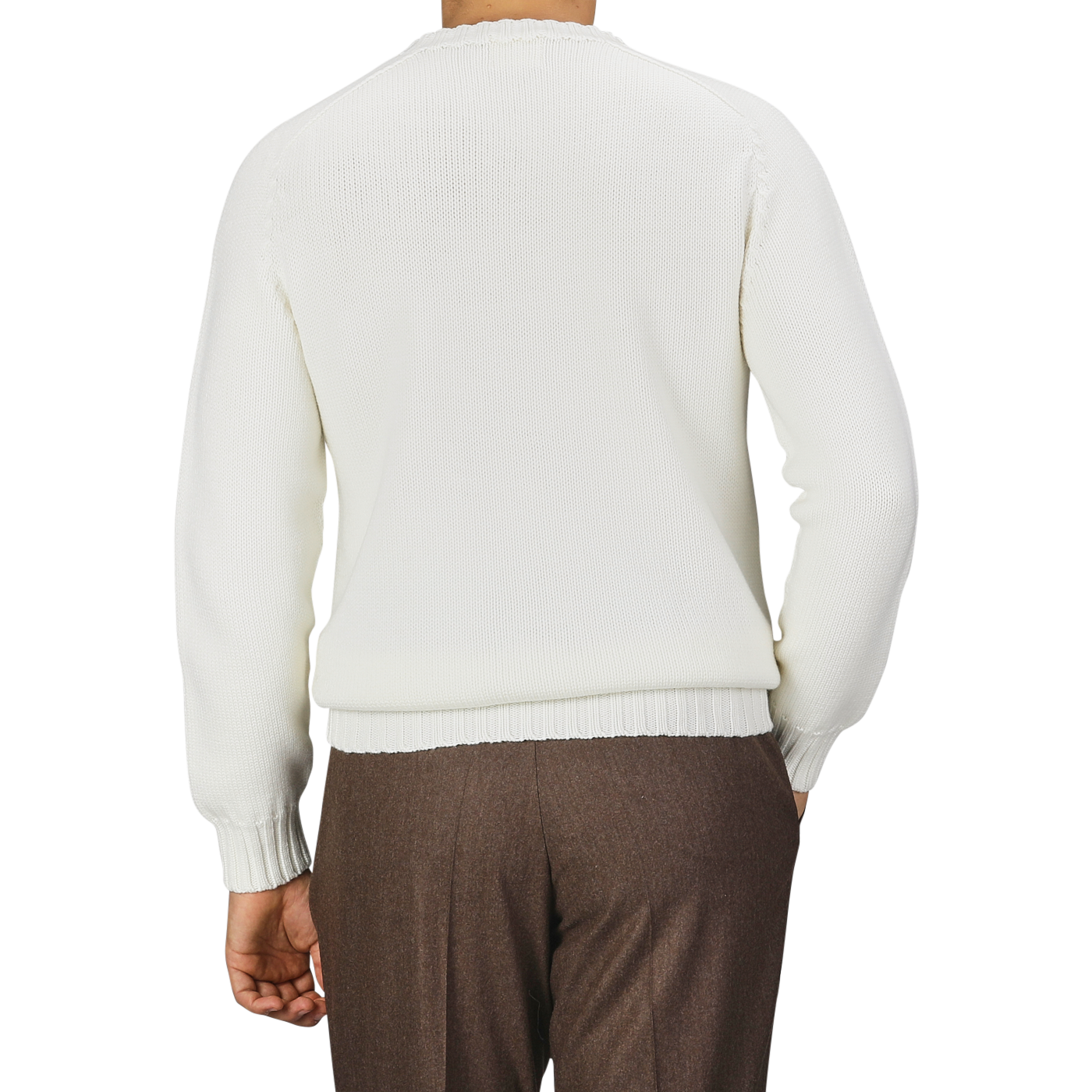 A person is shown from the back wearing an Ecru White Merino Wool Garbis Sweater by Nitto and brown trousers.