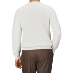 A person is shown from the back wearing an Ecru White Merino Wool Garbis Sweater by Nitto and brown trousers.