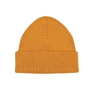 Introducing the Ocre Yellow Merino Wool Ara Beanie by Nitto: a mustard yellow knitted masterpiece with a folded brim, crafted by knitwear specialists. Made from luxurious merino wool, it promises both style and warmth.