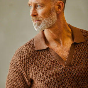 Man with a beard wearing a luxurious Sunspel Nougat Brown Cotton Chunky Knit Polo Shirt looking to the side.