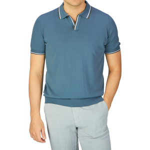 A man dressed in a Gran Sasso Ocean Blue Fresh Cotton Polo Shirt with a Capri collar and light gray trousers.