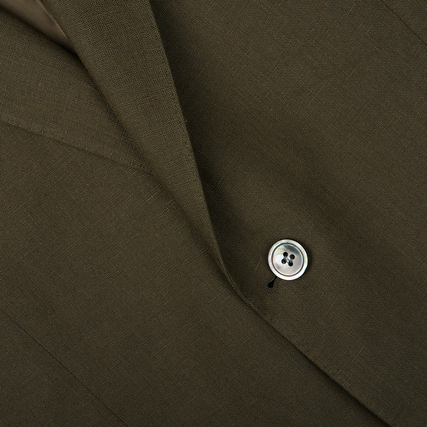 Close-up of a Green Leaf Pure Linen Suit fabric with a button, likely part of an Oscar Jacobson suit jacket, Fogerty model.