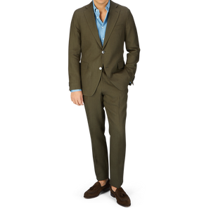 A man wearing an Oscar Jacobson Green Leaf model pure linen suit with a light blue shirt and brown loafers.
