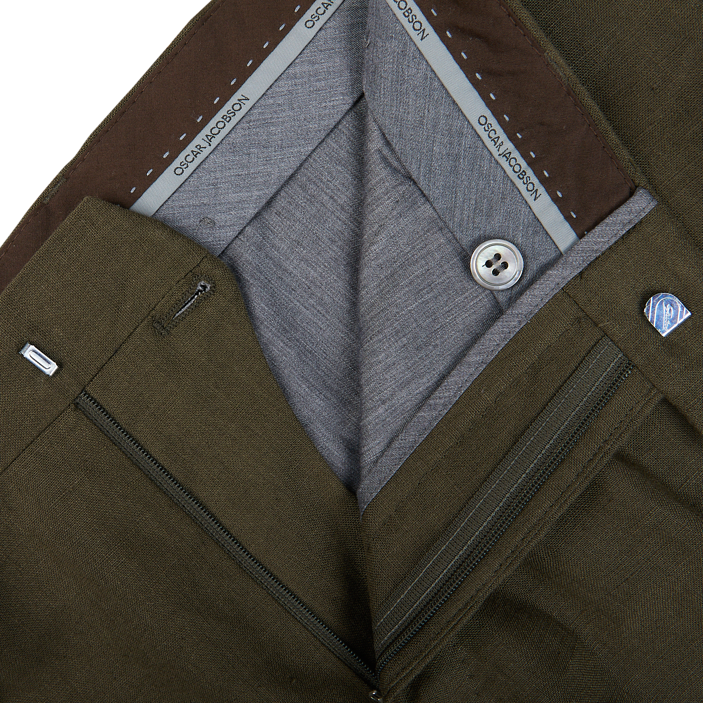 Close-up of a layered men's outfit with an Oscar Jacobson Green Leaf Pure Linen Suit jacket, grey vest, and white shirt.