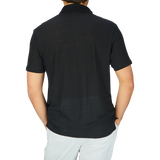 The man is wearing a Paige black linen Capri collar polo shirt, which is breathable and comfortable thanks to its linen fabric.