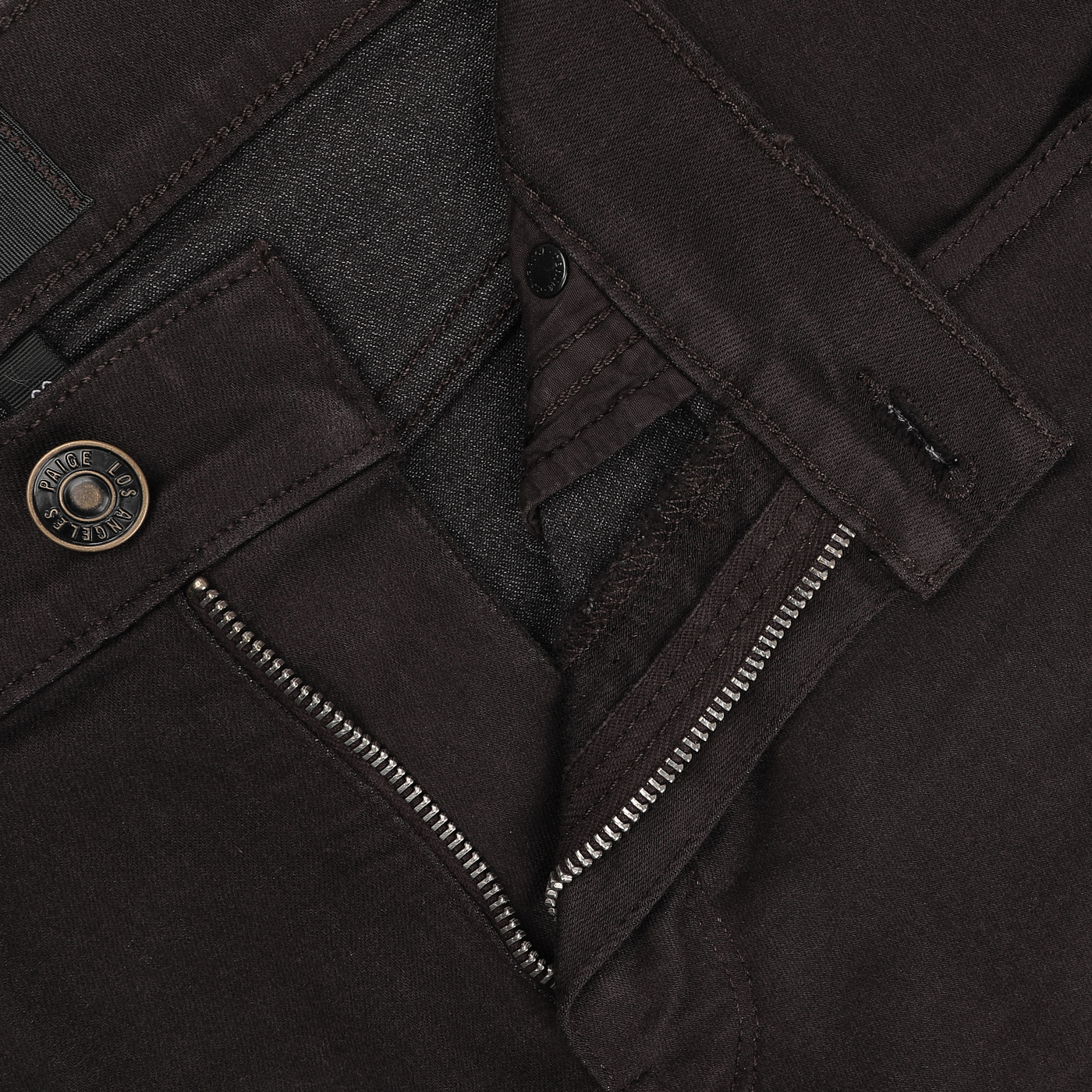 Close-up of a partially unzipped dark brown pair of Paige's Brown Cotton Transcend Normandie Jeans, highlighting the straight leg design with a metal button and intricate stitching details, crafted from advanced Transcend fabric.