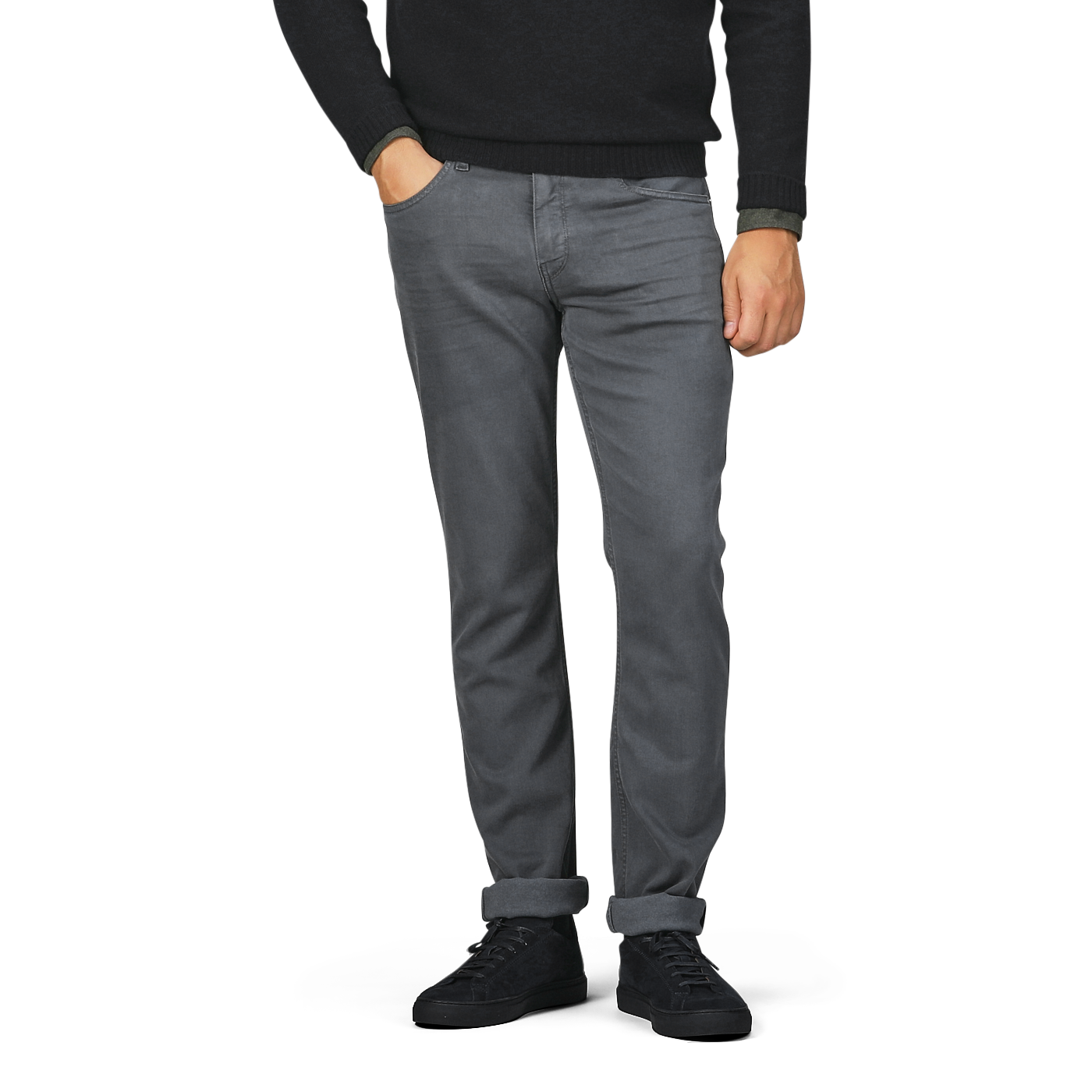 A person wearing a black long-sleeve shirt, black shoes, and Paige Charcoal Cotton Transcend Federal Slim Jeans in onyx grey stands with hands in front pockets. The jeans, made from comfortable Transcend fabric, are rolled up at the cuffs. The head and upper body are not visible.