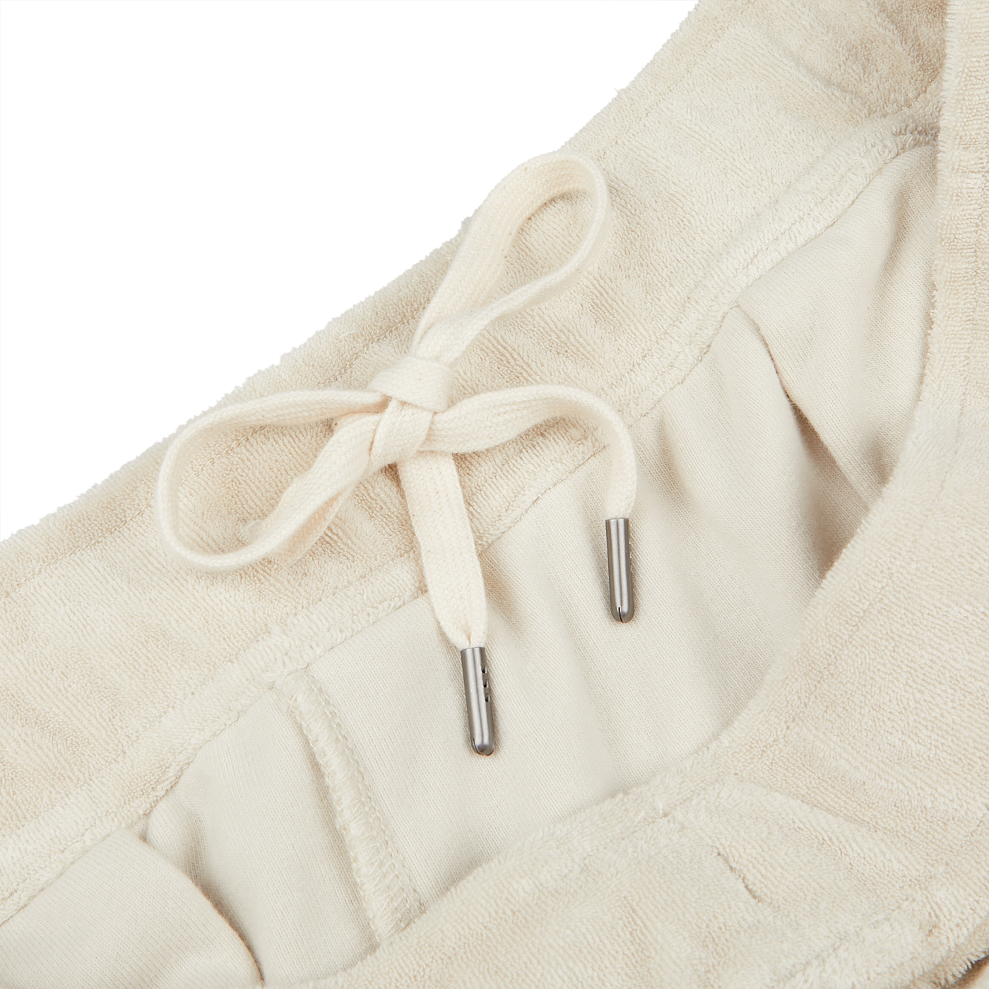 Close-up image of a beige garment, Cream Beige Cotton Towelling Shorts made from a soft towelling cotton blend by Paige, with an adjustable drawstring waist featuring metal aglets.