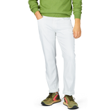 Man in green sweater and Paige Icecap White Cotton Transcend Federal Slim Jeans standing with one hand in pocket, wearing multicolored sneakers.