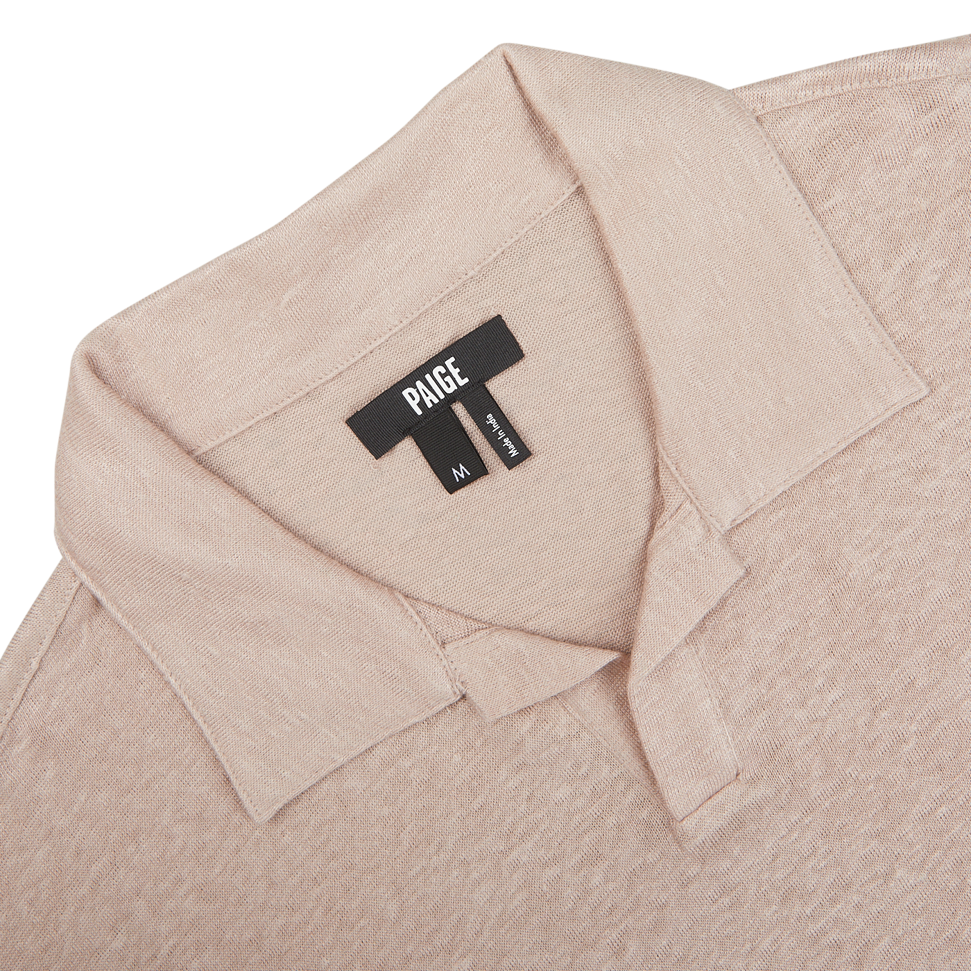 Close-up of a Light Pink Linen Capri Collar Polo Shirt's label with the brand "Paige" and size "M" on a light background.