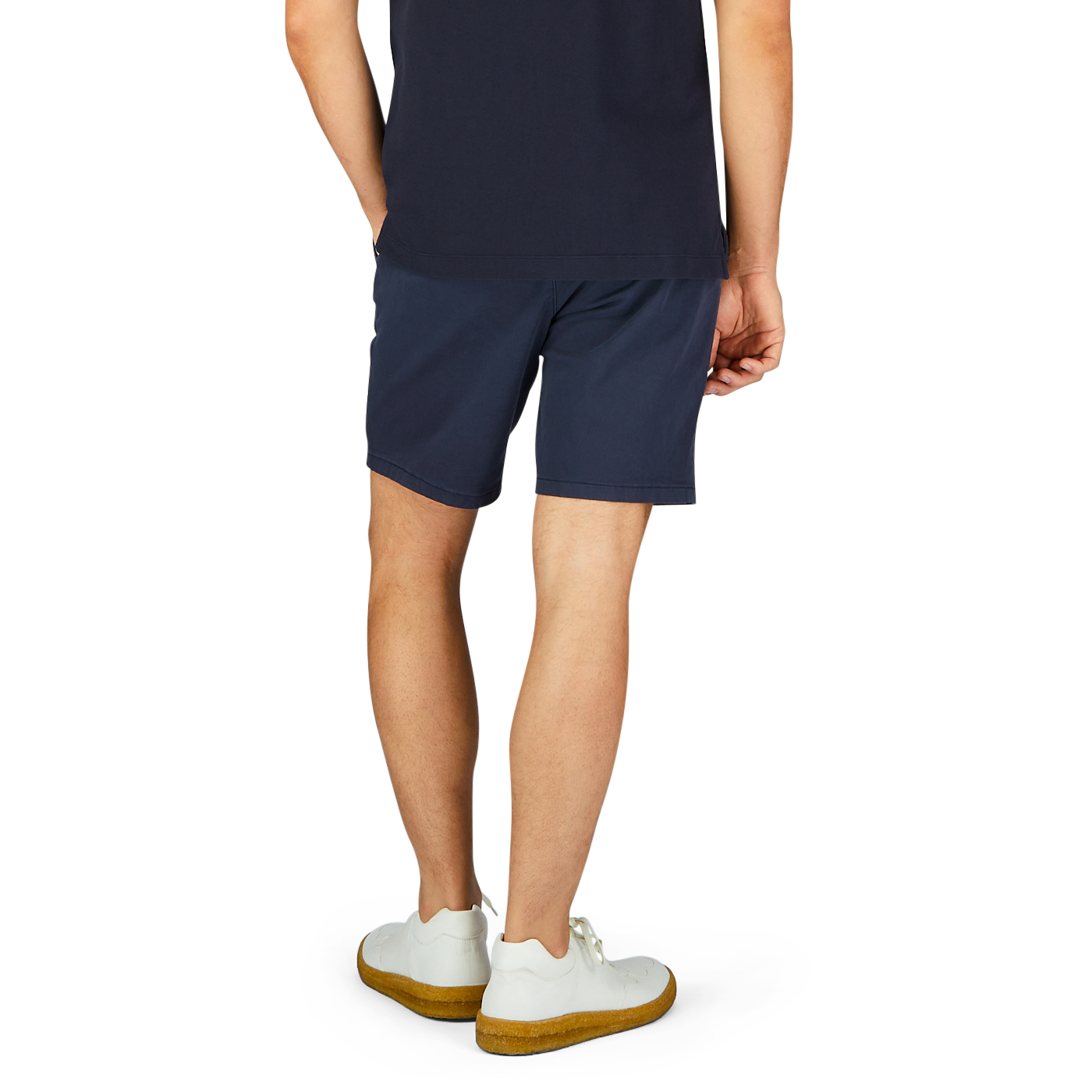 Man standing wearing Paige navy blue cotton blend Phillips shorts and white sneakers with yellow soles.