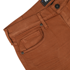 Close-up image of the waistband and pockets of Paige's Rust Brown Cotton Transcend Federal Slim Jeans on a white background. These comfortable fit pants feature a button and a visible brand label near the waistband.