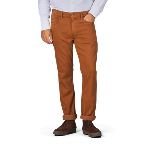 A person wearing a white shirt and Paige Rust Brown Cotton Transcend Federal Slim Jeans rolled up at the cuffs, paired with brown shoes. The head is not visible in the image, but the comfortable fit of the outfit suggests ease and style.