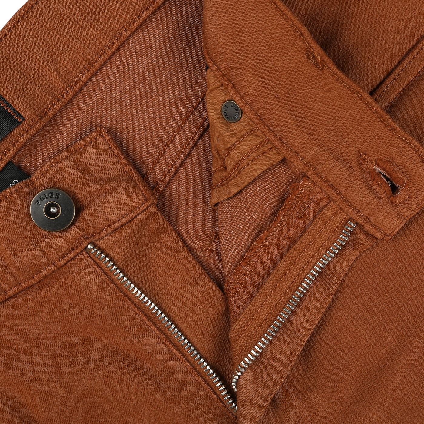 Close-up of Paige Rust Brown Cotton Transcend Federal Slim Jeans showcasing the waistband, zipper, button, and clasp. The partially undone zipper reveals the inside fabric. These jeans deliver a comfortable fit with their high-quality Transcend fabric.