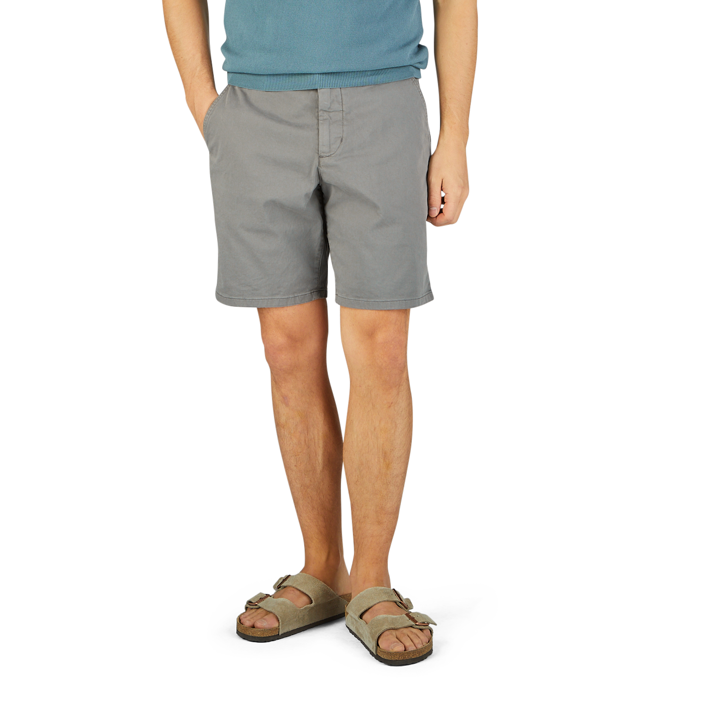 Man in a blue t-shirt and Slate Grey Cotton Blend Phillips shorts by Paige, wearing beige sandals, standing on a yellow textured surface.
