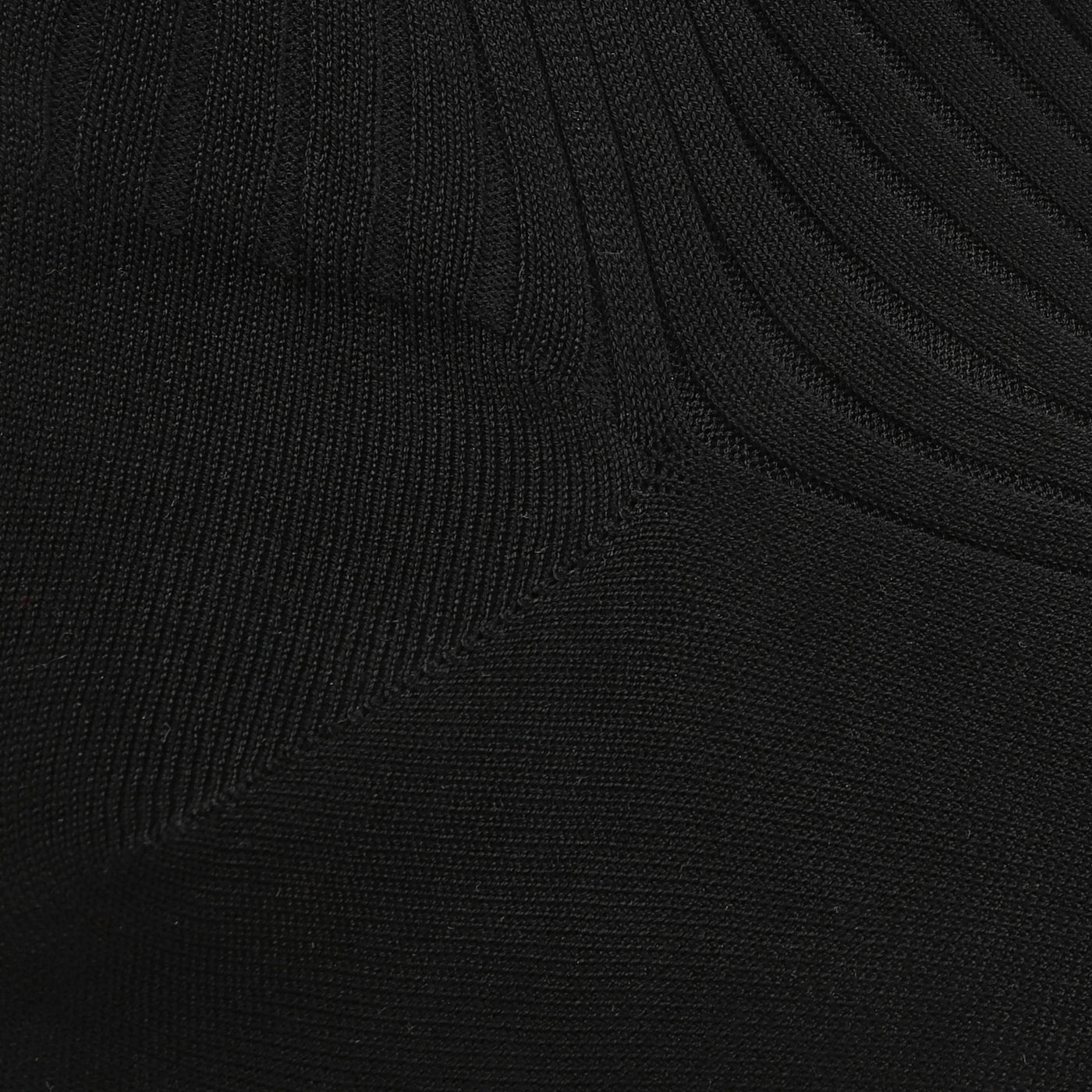 Close-up of Black Egyptian Cotton Isle Danvers Ankle Socks by Pantherella, featuring a ribbed texture and subtle seam detail, akin to fine cotton lisle yarn in men's dress socks.