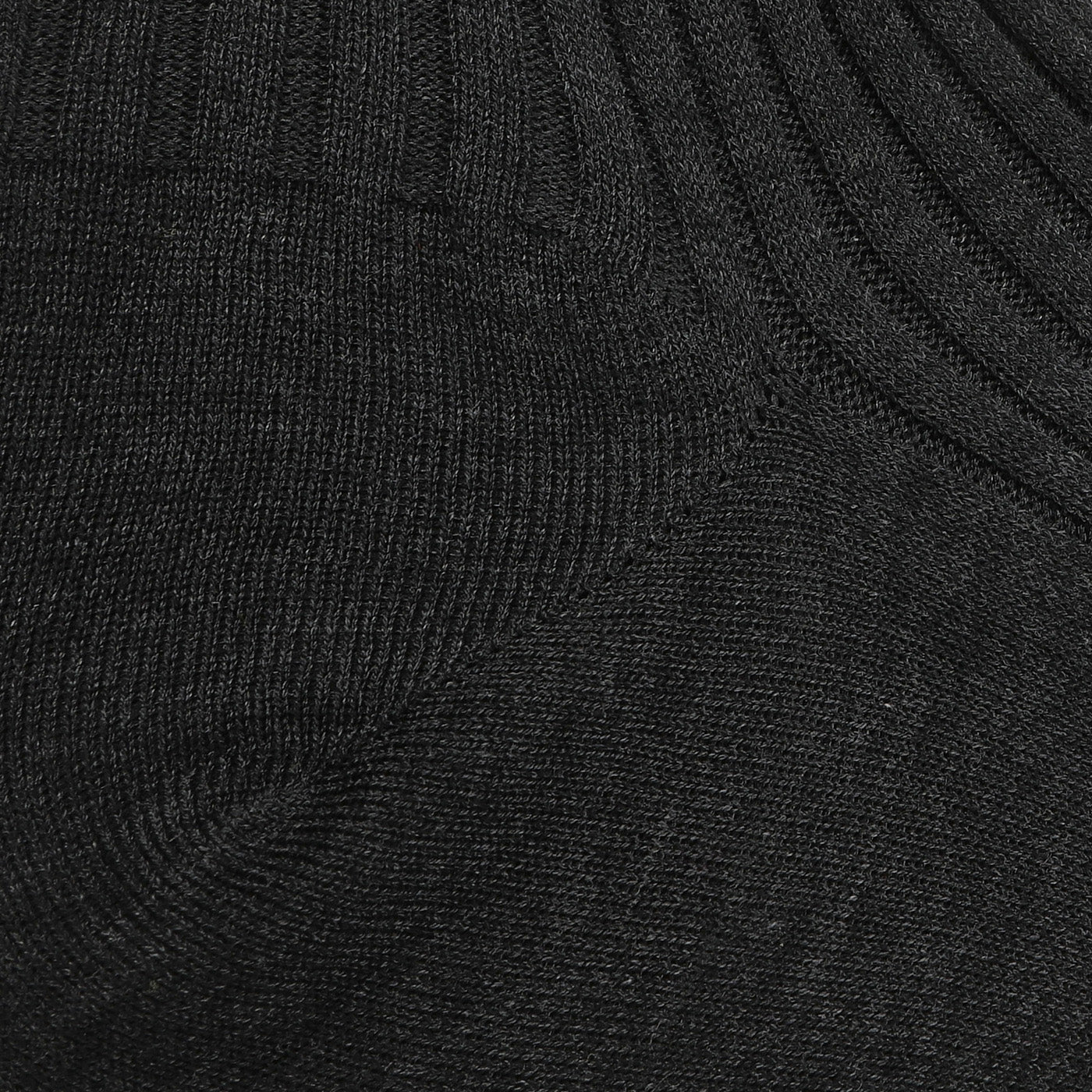 A close-up of Pantherella's Charcoal Egyptian Cotton Isle Danvers Ankle Socks reveals a ribbed fabric with visible texture and stitching, reminiscent of fine cotton lisle yarn.