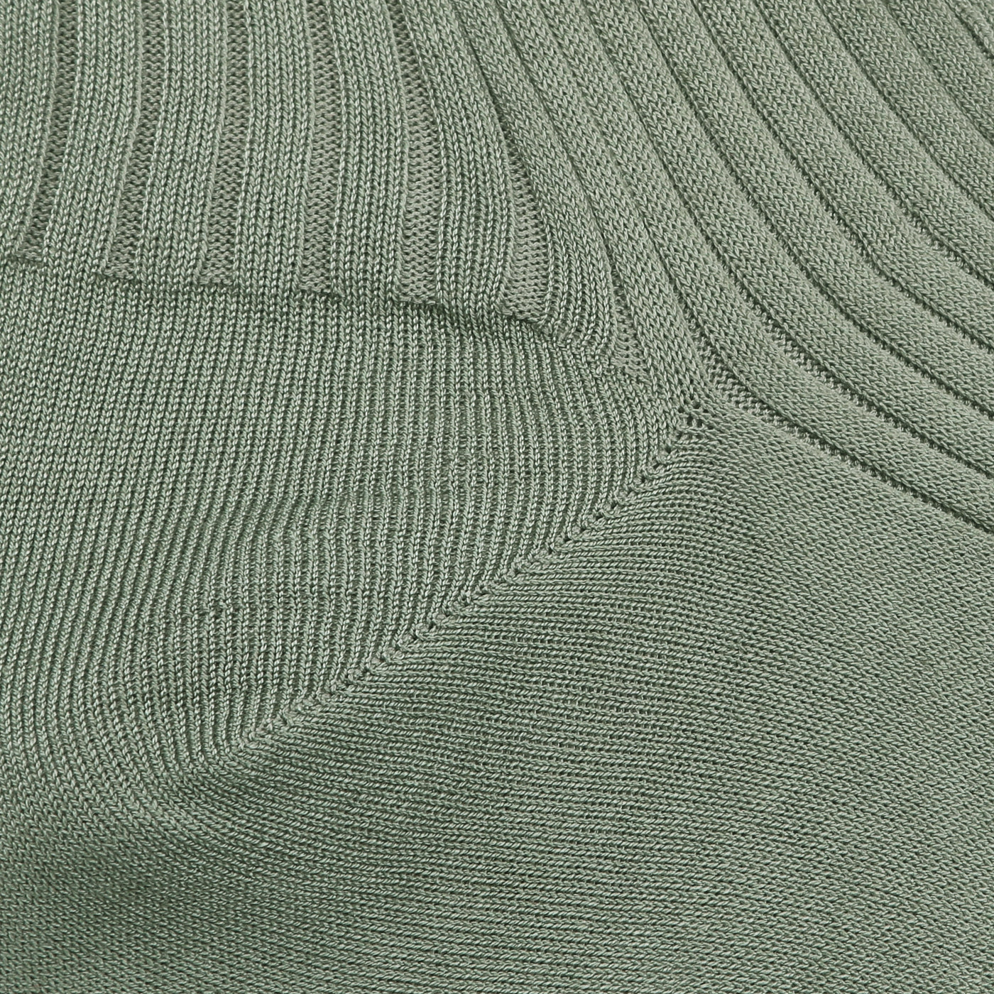 Close-up of sage Egyptian cotton fabric, similar to the luxurious texture of Pantherella's Isle Danvers ankle socks, showcasing two intersecting ribbing patterns.