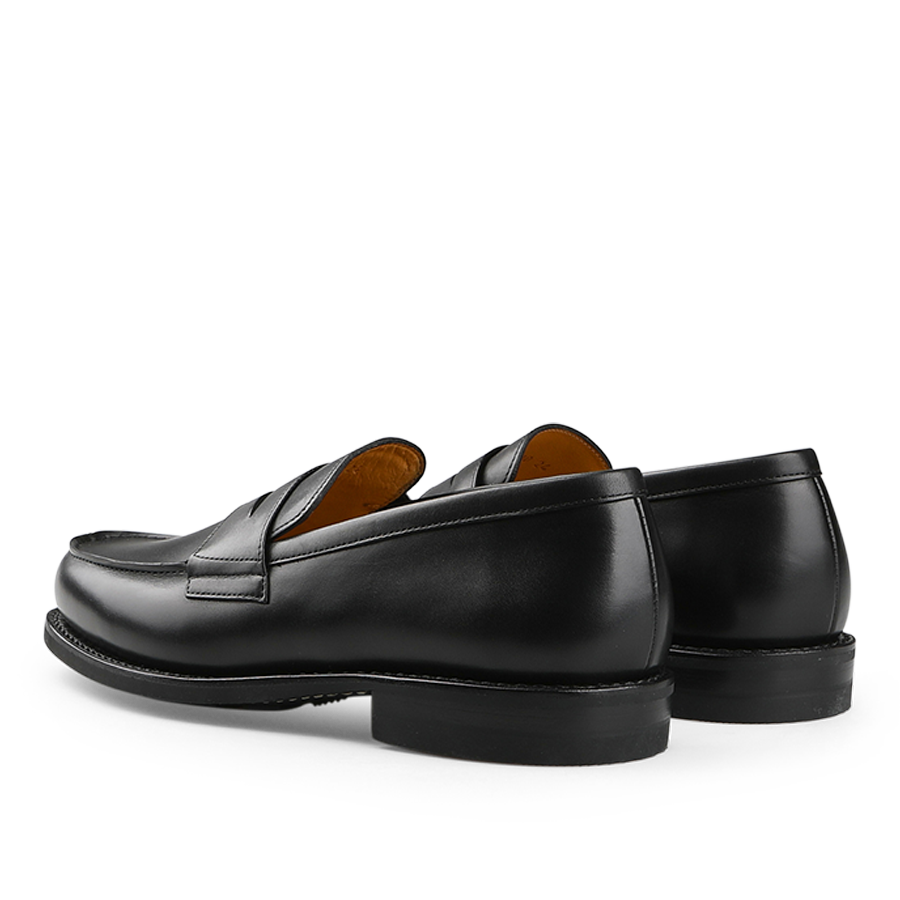 Black Leather Adonis Rubber Sole Loafers by Paraboot, featuring a stitched apron toe and low heel, are elegantly displayed at an angle on a white background.