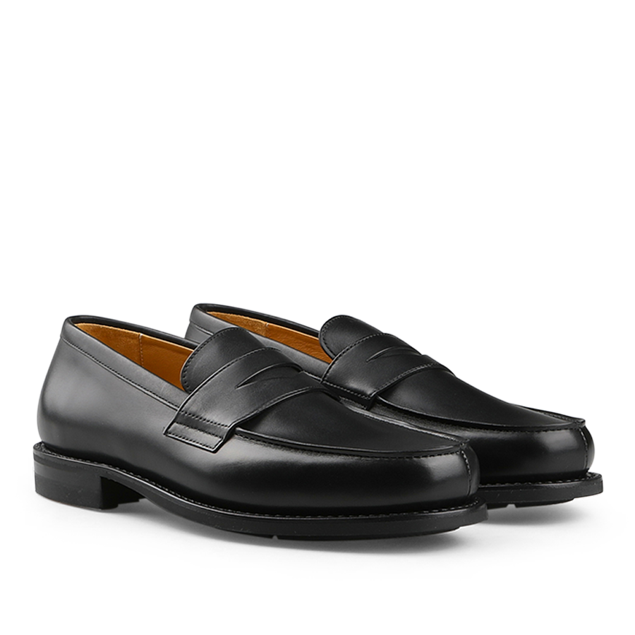 A pair of Paraboot Black Leather Adonis Loafers with a rounded toe and rubber sole is showcased on a white background.