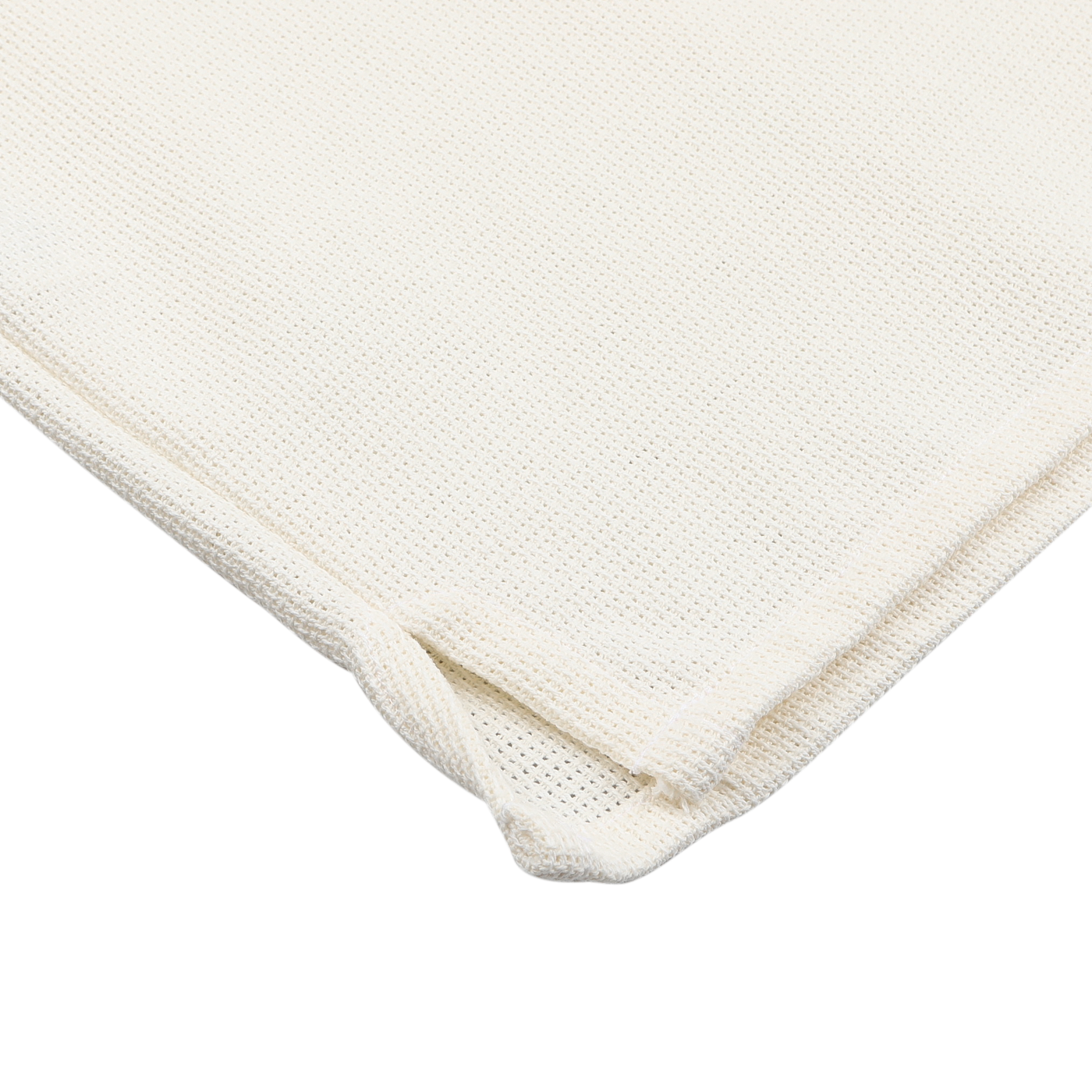 Close-up of the corner of a folded Cream Dry Cotton Cuban Collar Shirt by Peregrine, showcasing its off-white, waffle-textured fabric on a plain white surface.