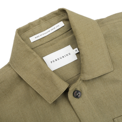 Khaki green linen Grange shacket by Peregrine, labeled "Made in England Since 1796," features a collar and one visible button.