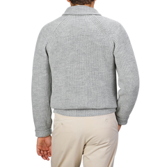 The person is wearing a Light Grey Wool Ford Zip Neck Sweater by Peregrine and beige pants, displayed from the back against a plain gray background.