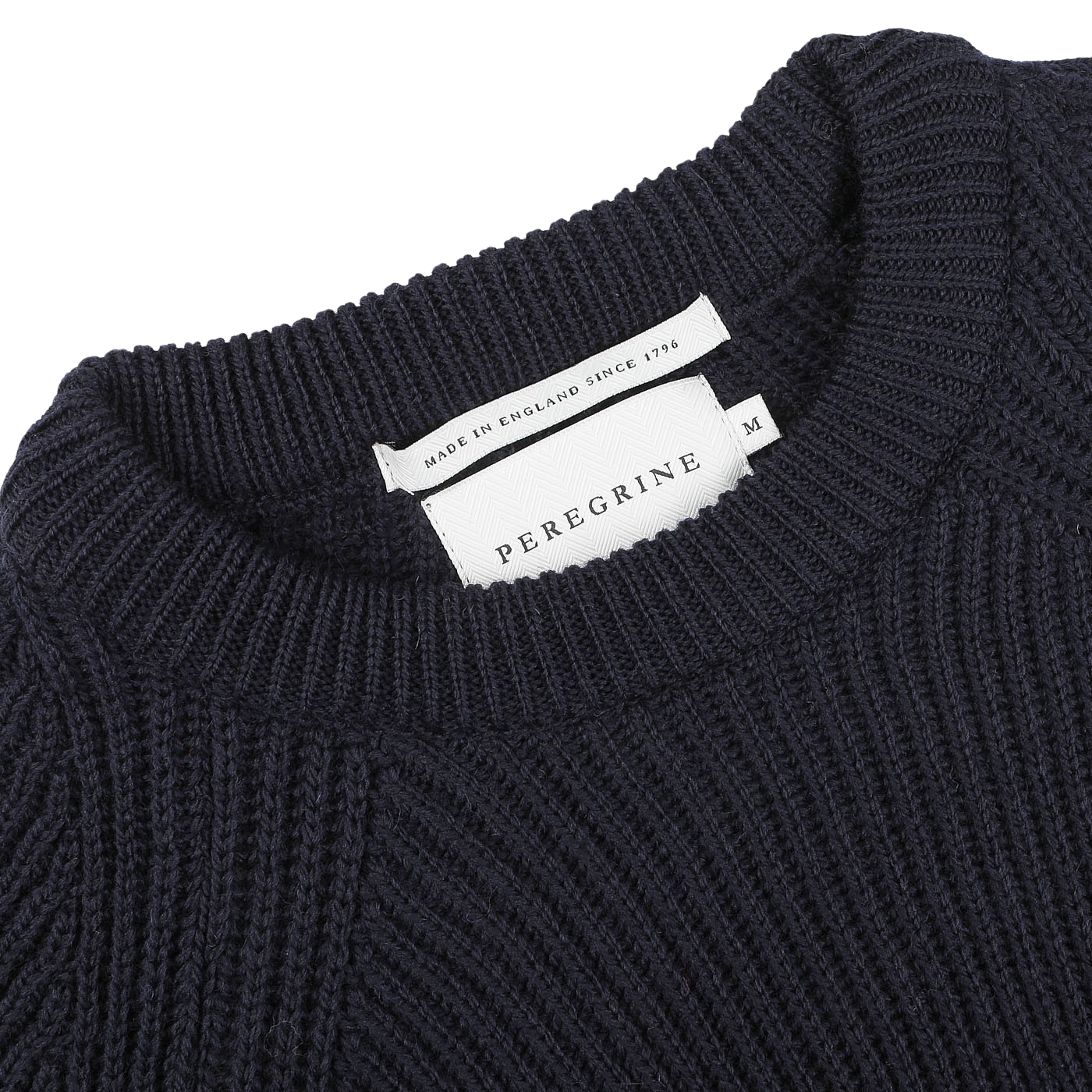 Close-up of a navy blue wool Ford raglan crewneck showing a "Peregrine" label and a tag indicating "Made in England since 1796," exemplifying premium British knitwear.