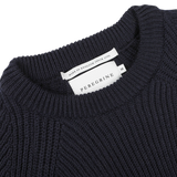 Close-up of a navy blue wool Ford raglan crewneck showing a "Peregrine" label and a tag indicating "Made in England since 1796," exemplifying premium British knitwear.