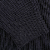 Close-up of a dark-colored, ribbed knit fabric from a Navy Blue Wool Ford Raglan Crewneck by Peregrine, showing detailed texture and pattern.