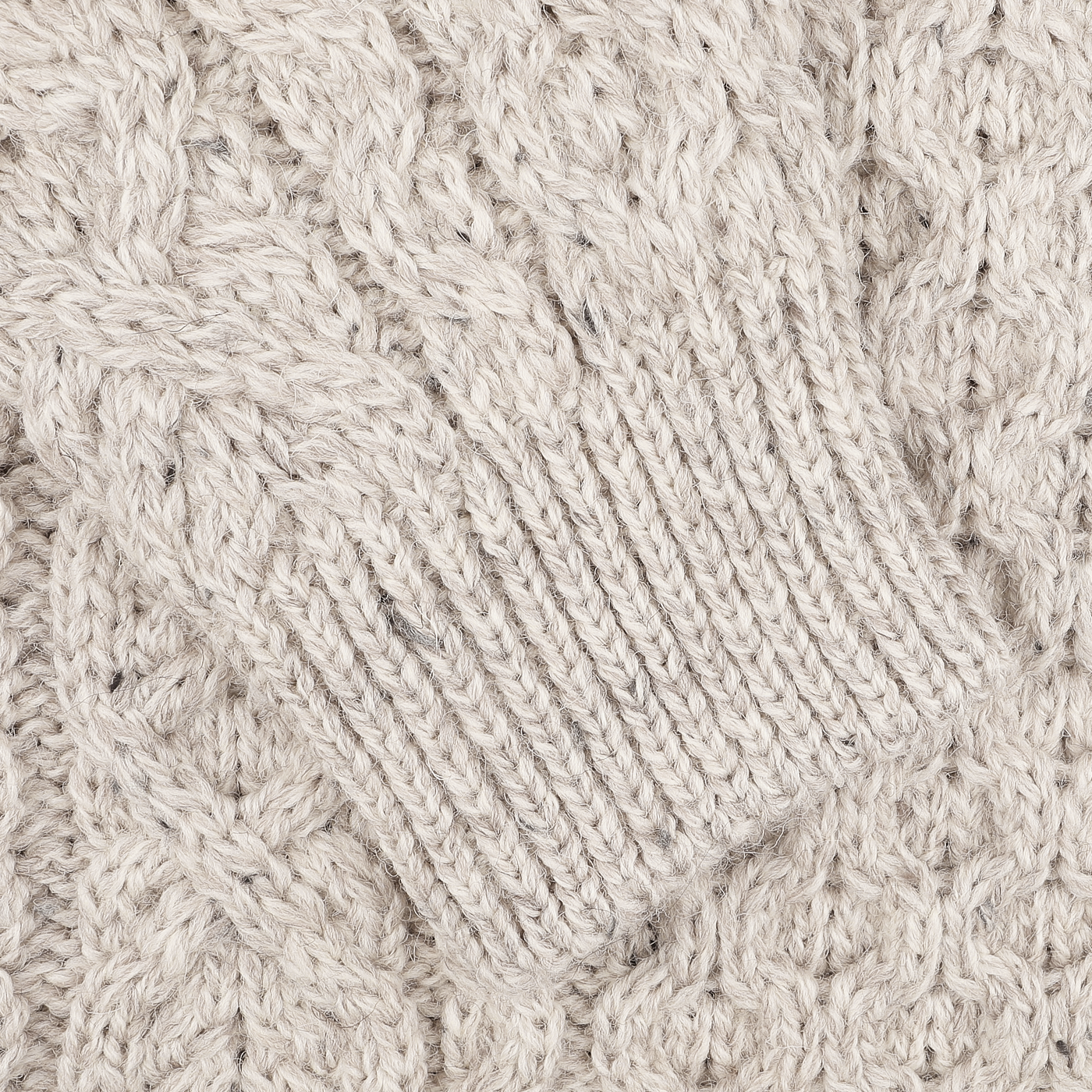 Close-up of a textured, Skiddaw Beige Merino Wool Hudson Aran Jumper by Peregrine, featuring a cable pattern and ribbed cuff that highlights the tradition of British knitwear.