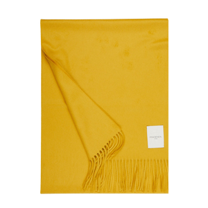 A Mustard Yellow Cashmere Aeternum Scarf with fringed endings on a white background.