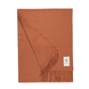 A Muted Orange Cashmere Aeternum Scarf with fringed endings on a white background by Piacenza Cashmere.